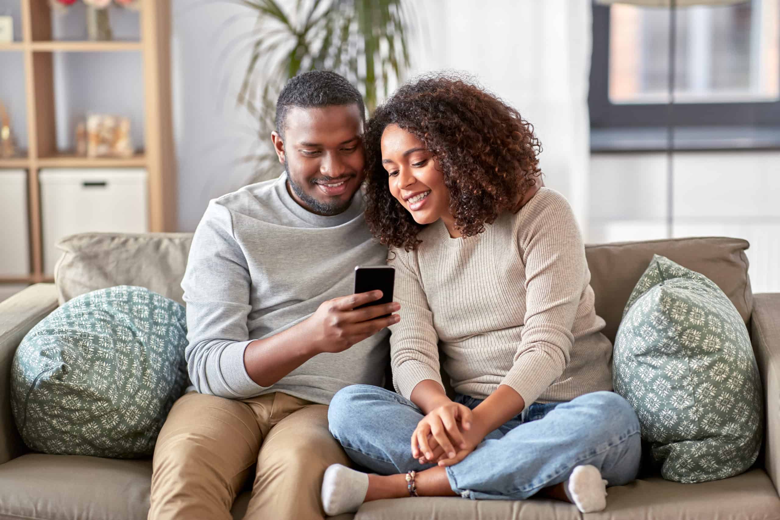 Happy african american couple with smartphone